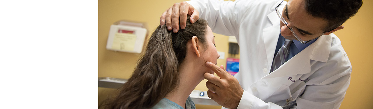 Dermatologist examining a woman's face